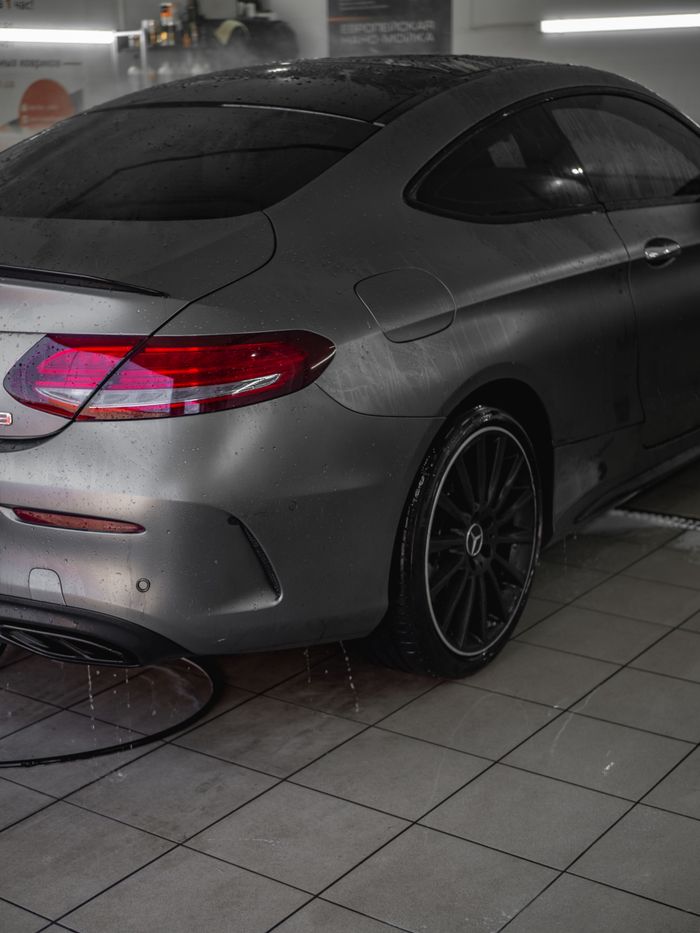 mobile-01 A sleek Mercedes Benz coupe undergoing a car wash, showcasing wet surfaces and elegant design.